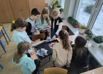 Uczniowie klasy czwartej sprawdzają działanie maszyny do rysowania