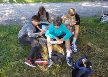 Grupa uczniów podczas zajęć terenowych nad starorzeczem