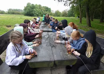 Uczniowie klasy 5 podczas wyplatania koszyków