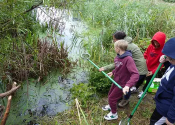 Uczniowie podczas połowu organizmów ze starorzecza Warty