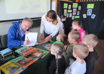 Marcin Kozioł podpisujący książki przedszkolakom