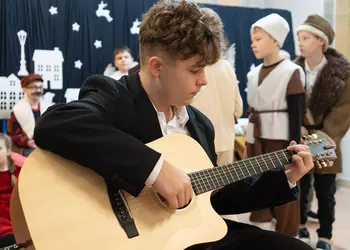 Borys gra kolędę na gitarze