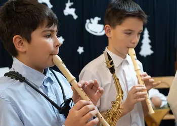 Chłopcy z klasy piątej grają kolędę na fletach