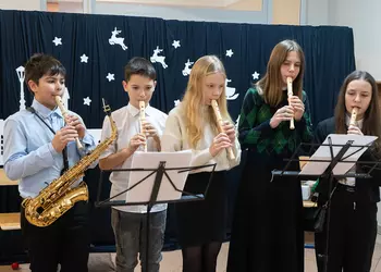 Pięcioro uczniów gra kolędę na fletach