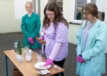 Uczennica klas 8 podczas doświadczenia z wodą