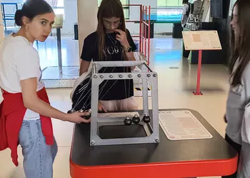 Dziewczyny badają zasadę działania kołyski Newtona