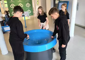 Uczniowie wykonują doświadczenie