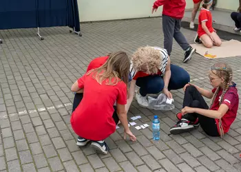 Uczennice wraz z panią wicedyrektor układają hasło