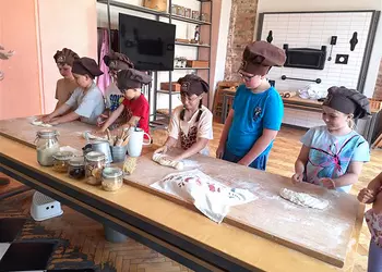 Dzieci wyrabiają ciasto podczas warsztatów