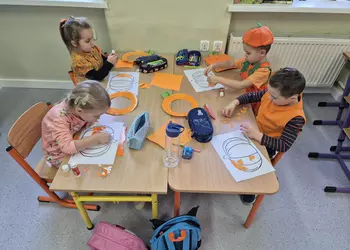 Najmłodsze dzici wyklejają kontur dyni
