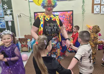 Dzieci w tańcu z panią przebraną za klowna.