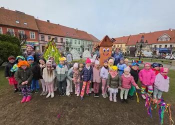Oddziały przedszkolne z wiatrakiem Sworacym i swoimi paniami na tle Pani wiosny.