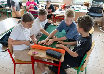 Uczniowie klasy 4 wykonują papierowy kwiat
