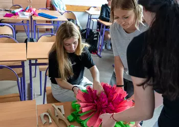 Uczniowie klasy 8b wykonują papierowy kwiat