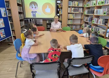 Młodsza grupa słucha pani Anity o zasadach bezpieczeństwa podczas wakacji.