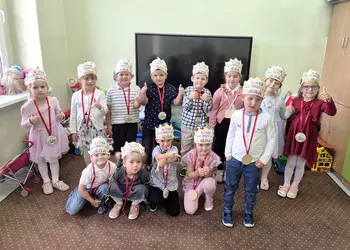 Młodsza grupa przedszkolna w koronach z medalami Super Przedszkolaka