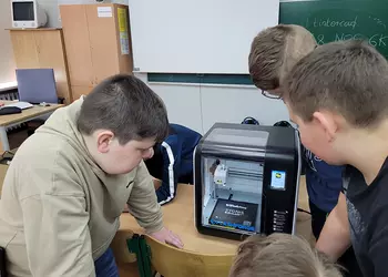 Uczniowie obserwują wydruk w drukarce 3D