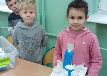 Uczniowie prezentują budowlę wykonaną z klocków Korbo