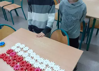 Uczniowie prezentują polską flagę zaprojektowaną z klocków Korbo