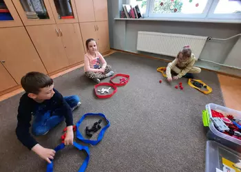 Troje uczniów wykorzystujących klocki podczas zajęć