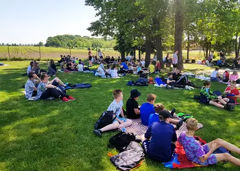 Uczniowie odpoczywają po konkurencjach podczas Dnia Dziecka