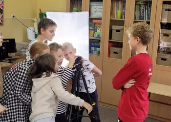 Uczniowie fotografują swojego kolegę