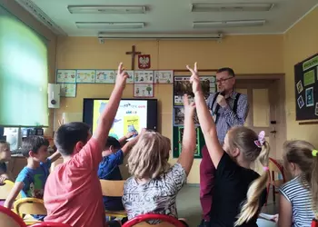 Uczniowie odpowiadający na pytania pisarza