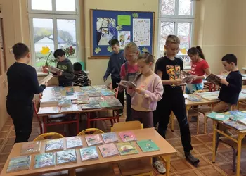 Uczniowie klasy trzeciej oglądający nowe książki