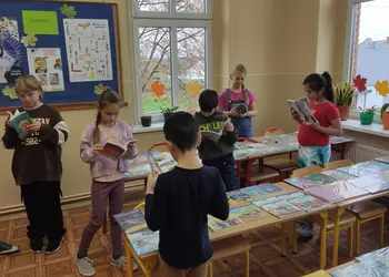 Uczniowie zapoznający się z nowymi książkami